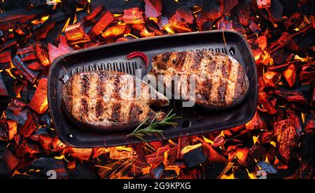 Deux steaks de saumon grillés sur grille barbecue sur des morceaux chauds de charbons. Vue de dessus. Banque D'Images