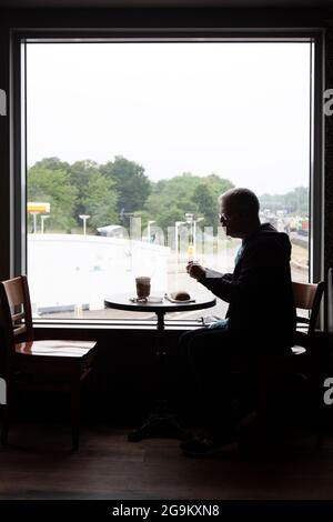 Silhouette of Man Eating au restaurant de la porte d'entrée de Londres, sur la M1, au Royaume-Uni Banque D'Images