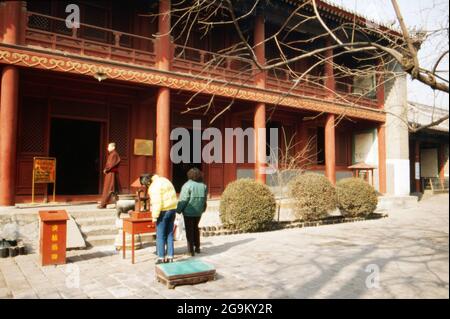 Gläubige opfern Weihrauch vor dem Yonghe Tempel à Pékin, Chine 1998. Croyants tirant des bâtons parfumés à l'entrée du temple Yonghe à Beijing, Chine 1998. Banque D'Images