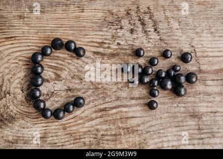 Cassis mûr frais avec des feuilles d'origine sur fond rustique en bois ancien gros plan. Alimentation saine, récolte, vitamine Banque D'Images