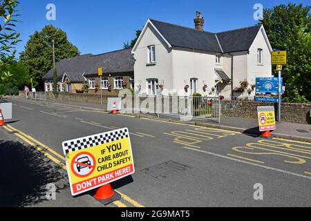 Les restrictions de stationnement dans la rue du village à l'extérieur de la porte d'entrée de l'école primaire ne sont pas assez d'affiches de sécurité routière pour enfants en usage à Kelvedon Hatch Essex, Angleterre Banque D'Images