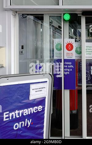 Gros plan supermarché Tesco porte coulissante entrée à sens unique système de feux de circulation comptage des acheteurs entrant éviter la surpopulation dans Covid 19 pandémie Banque D'Images