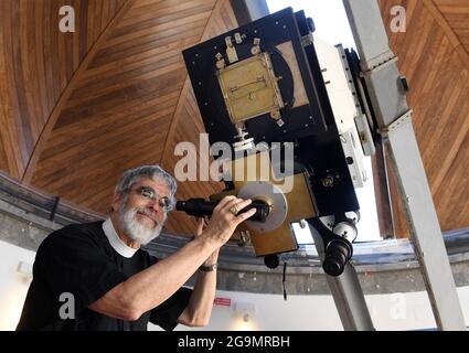 Astronome papal le frère jésuite Guy Consomagno, directeur de l’Observatoire du Vatican depuis 2015, examine à travers le télescope «carte du ciel» un modèle du XIXe siècle avec une focale de 360 cm le 2021 juin au siège de la «Specola Vatican» (Observatoire du Vatican) à Castel Gandolfo, en Italie, le 14 juin, 2021. L'Observatoire du Vatican, l'une des plus anciennes institutions de recherche astronomique du monde, a son siège à la résidence d'été papale de Castel Gandolfo, en dehors de Rome. Pour la première foreshadue de l'Observatoire peut être tracé à la constitution par le Pape Grégoire XIII d'a Banque D'Images