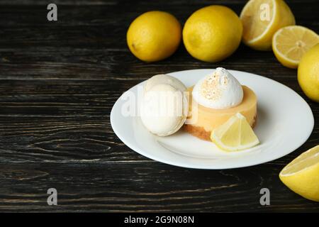 Assiette avec cupcake et macarons, et citrons sur table en bois Banque D'Images