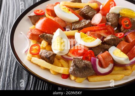 Pique macho est un plat bolivien composé d'une couche de frites enfouies sous un tas de bœuf haché, saucisses, œufs, tomates, oignons, poivrons Banque D'Images