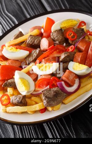 Pique macho est un plat très populaire de Bolivie fait de coupes de bœuf et de saucisses frites avec des frites, des œufs, des piments et des tomates dans l'assiette Banque D'Images