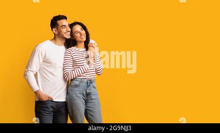 Offre agréable. Couple arabe du millénaire s'embrassant et regardant de côté à Copy Space Banque D'Images