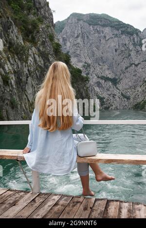 Femme blonde jouissant d'une vue sur la montagne sur un ferry Banque D'Images