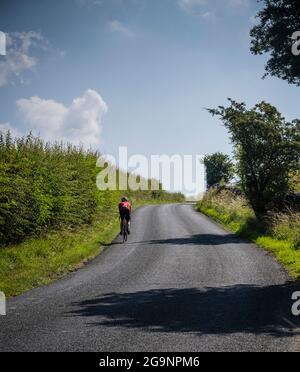 Cycliste mâle mature en haut de la colline de Whitewell, Bowland, Lancashire, Royaume-Uni. Banque D'Images