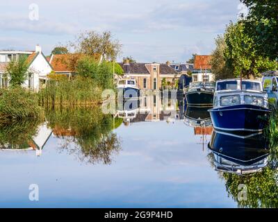 Bateaux dans le canal de Wargaastervaart dans le village de Wergea, Leeuwarden, Frise, pays-Bas Banque D'Images