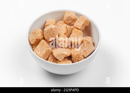 Cubes de sucre de canne brun isolé sur fond blanc Banque D'Images