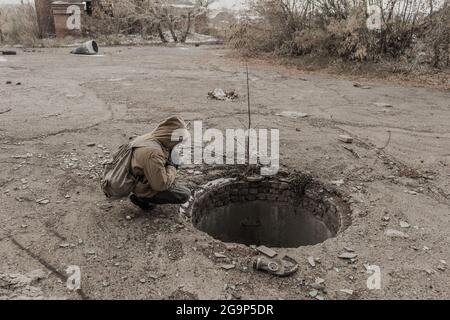 garçon errant. garçon avec une arme. garçon va dans un bâtiment abandonné. garçon se tient devant un bâtiment. Après l'apocalypse. Homme voyageant à pied dans un post- Banque D'Images