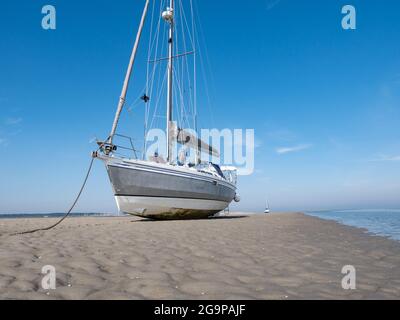 Voilier séché sur sable plat à marée basse de la mer de Wadden, île de Richel près de Vlieland, pays-Bas Banque D'Images