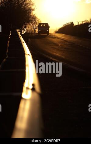 garde-corps avant et vue avant de la voiture avec leurs lumières allumées au coucher du soleil Banque D'Images