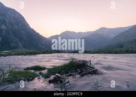 Vue générale sur les montagnes et la rivière Kishanganga qui coule au crépuscule à Dawar. Gurez se trouve le long de la ligne de contrôle (LOC) dans la partie nord du Cachemire. La vallée de Gurez a été la clé de la route de la soie de l'Europe à Kashgar en Chine et demeure de la tribu de Dard parlant shina, mais elle n'a été ouverte au monde qu'en 2007. Avant 2007, Gurez n'était ouvert qu'à l'époque coloniale lorsque les voyageurs venaient explorer la vallée. La ligne de contrôle traverse maintenant la vallée idyllique, séparant les dards de leurs frères Indo-aryens à Gilgit, Chilis et Astore, au Pakistan. (Photo par Irrees Abbas/SOPA image Banque D'Images