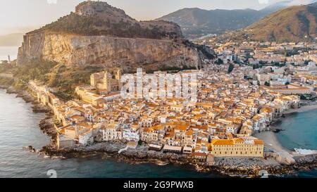 Lever de soleil au-dessus du port de Cefalu, Sicile, Italie, vue panoramique aérienne de la vieille ville avec des maisons de front de mer colorées, la mer et la falaise de la Rocca. Banque D'Images