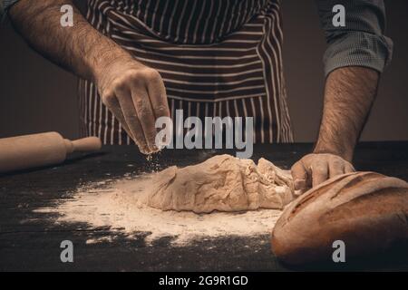 Homme mains pétrir la pâte. Chef de pain et de petits pains Banque D'Images