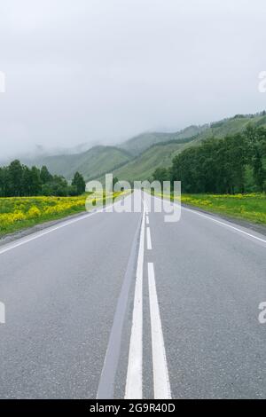 Route de montagne brumeuse en République de l'Altaï, Sibérie, Russie. Concept de trébuchement sur route. Banque D'Images