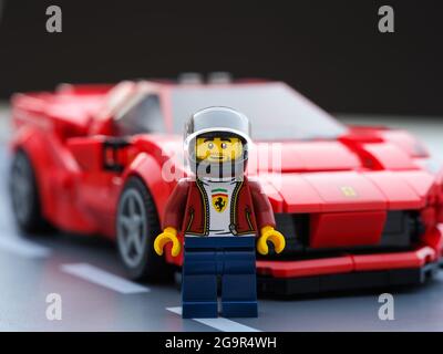 Tambov, Fédération de Russie - 09 juillet 2021 le pilote de Lego minifigure et sa voiture Ferrari F8 Tribto par LEGO Speed Champions sur la plaque de base. Bsck noir Banque D'Images
