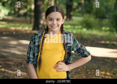 Fille scout mignon braides porter des vêtements à carreaux nature fond, concept de camp d'été Banque D'Images