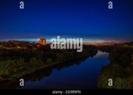 Des nuages Noctilucent au-dessus de la rivière Neris et des arbres Banque D'Images