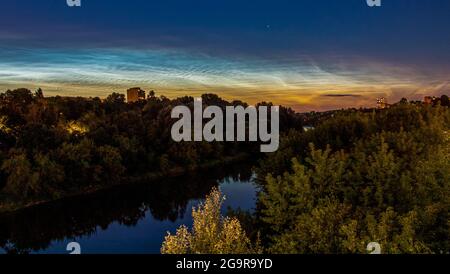 Des nuages Noctilucent au-dessus de la rivière Neris et des arbres Banque D'Images