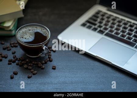 Photo en grand angle d'une tasse de café près d'un ordinateur portable sur un bureau Banque D'Images