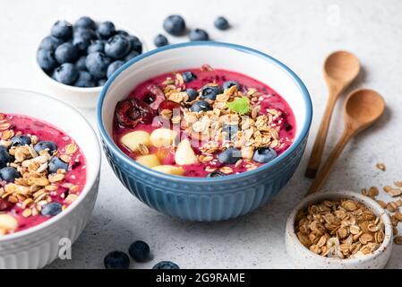 Bol de smoothie aux myrtilles sain avec granola et diverses garnitures de baies Banque D'Images