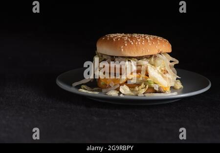 Hamburger McDonalds Big Mac plaqué sur une soucoupe grise sur fond sombre Banque D'Images