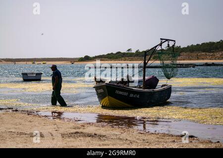 Lagoa (« lagune ») de Albufeira est situé sur la partie ouest de la péninsule de Setúbal. Pêcheur travaillant avec son chien sur le bateau. Prow d'un bateau. Banque D'Images