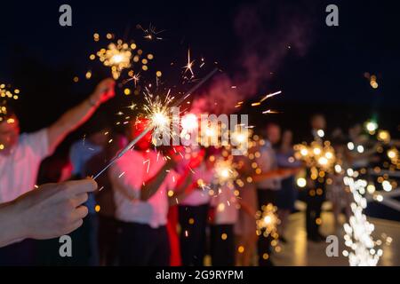 Photo montrant un groupe d'amis qui s'amusent avec des sparkers Banque D'Images