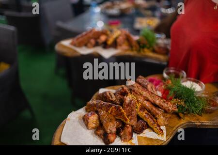 Waiter carrying deux plaques avec plat de viande sur certains événement festif, parti, réception de mariage ou événement Banque D'Images