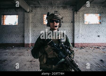 Gros plan d'un soldat professionnel entièrement équipé regardant la caméra Banque D'Images