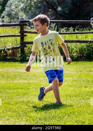 Jeune garçon jouant sur l'herbe Banque D'Images