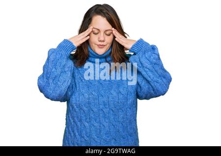 Jeune femme de taille plus portant des vêtements décontractés avec la main sur la tête pour la douleur dans la tête parce que le stress. Souffrant de migraine. Banque D'Images