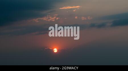 Coucher de soleil dans un ciel rempli de fumée. Banque D'Images