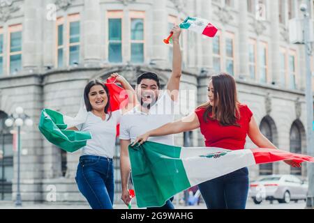 Groupe de fans mexicains de football tenant des drapeaux et des trompettes à Mexico Banque D'Images