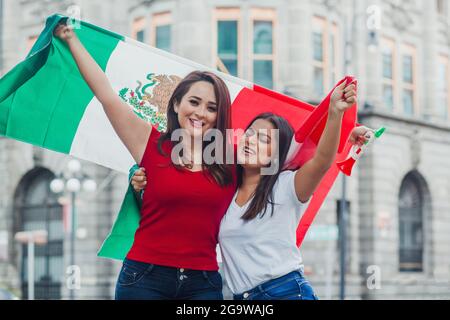 Femmes mexicaines souriantes avec drapeaux pour profiter de la fête de l'indépendance mexicaine Banque D'Images