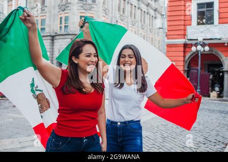 Femmes mexicaines souriantes avec drapeaux pour profiter de la fête de l'indépendance mexicaine Banque D'Images