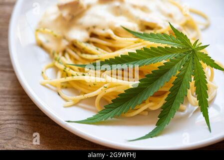 Cannabis nourriture nature herbe concept, Spaghetti carbonara sur l'assiette avec feuille de cannabis - plante de feuilles de marijuana Banque D'Images