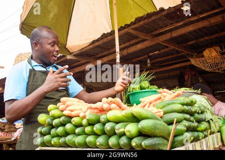 Photo de stock de l'épicerie africaine masculine avec un tablier, étonné comme il se tient et fixe à son téléphone Banque D'Images