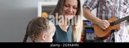 Femme et homme enseignant à la petite fille de jouer de l'instrument de musique Banque D'Images