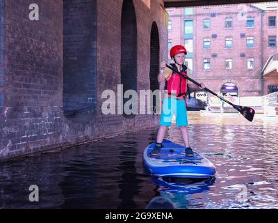 Garçon sur un paddle-board à Victoria Quay, au début du Sheffield et du canal Tinsley, Sheffield. Banque D'Images