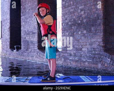 Garçon sur un paddle-board à Victoria Quay, au début du Sheffield et du canal Tinsley, Sheffield. Banque D'Images