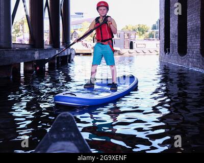 Garçon sur un paddle-board à Victoria Quay, au début du Sheffield et du canal Tinsley, Sheffield. Banque D'Images