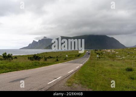 Flakstad, Norvège - 20 juillet 2021 : autoroute côtière sur les îles Lofoten avec peu de circulation par jour couvert Banque D'Images