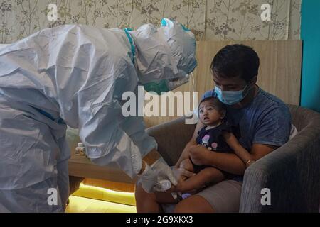 Badung, Indonésie. 27 juillet 2021. Un bébé a obtenu son examen médical de routine dans sa chambre à Wisma Bima Cottages II, Kuta. Le gouvernement local de Bali a centralisé les isolations Covid-19 pour les symptômes asymptomatiques et légers afin de faciliter le contrôle médical. Avant que des milliers de personnes ne meurent pendant la période d'auto-quarantaine dans leurs propres maisons, d'après les données du ministère indonésien de la Santé. Crédit : SOPA Images Limited/Alamy Live News Banque D'Images