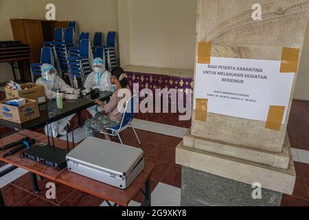 Badung, Indonésie. 27 juillet 2021. Une patiente isolée obtient son examen médical de routine à Wisma Bima Cottages II, Kuta. Le gouvernement local de Bali a centralisé les isolations Covid-19 pour les symptômes asymptomatiques et légers afin de faciliter le contrôle médical. Avant que des milliers de personnes ne meurent pendant la période d'auto-quarantaine dans leurs propres maisons, d'après les données du ministère indonésien de la Santé. Crédit : SOPA Images Limited/Alamy Live News Banque D'Images