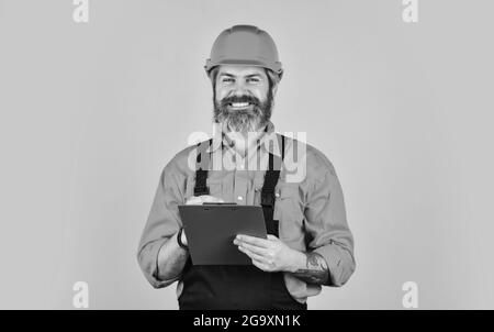 travailleur manuel dans un casque. travailleur avec le dossier dans l'uniforme de construction. ingénieur homme avec les croquis du projet de construction dans le dossier. Gestion Banque D'Images