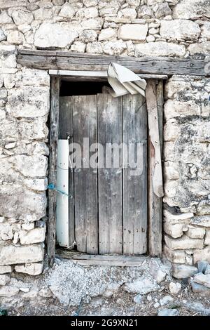 Ancienne porte rustique en bois d'une grange en pierre abandonnée Banque D'Images